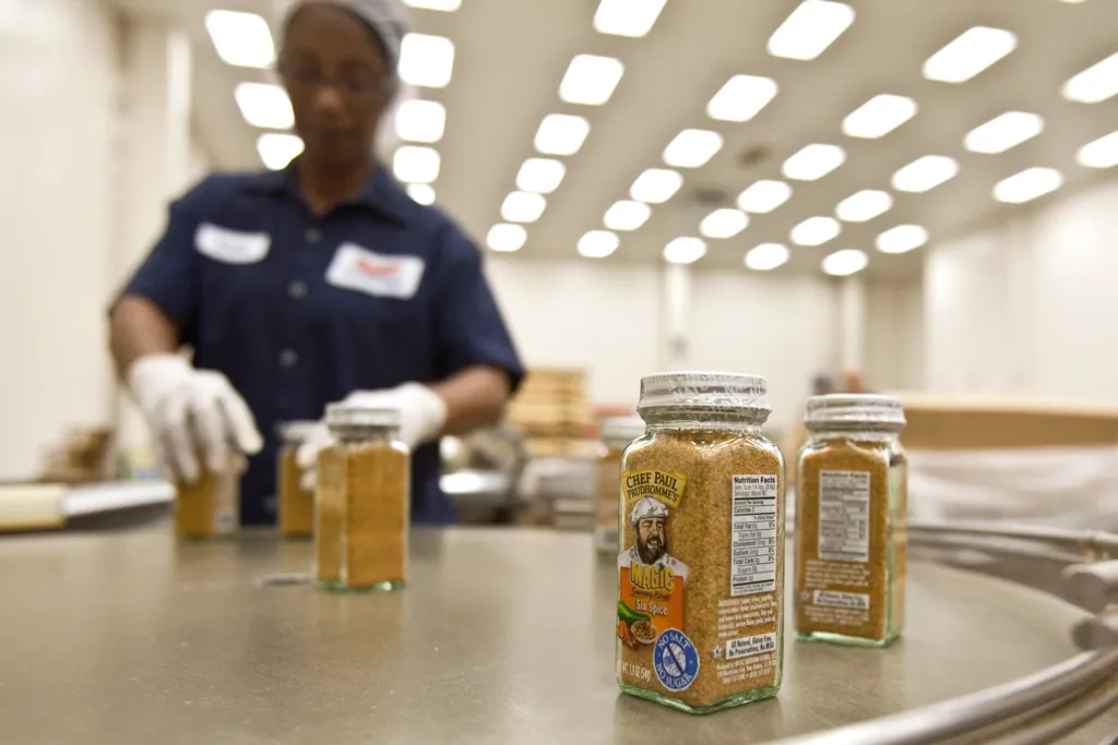 A woman packing Chef Paul Magic Seasoning containers