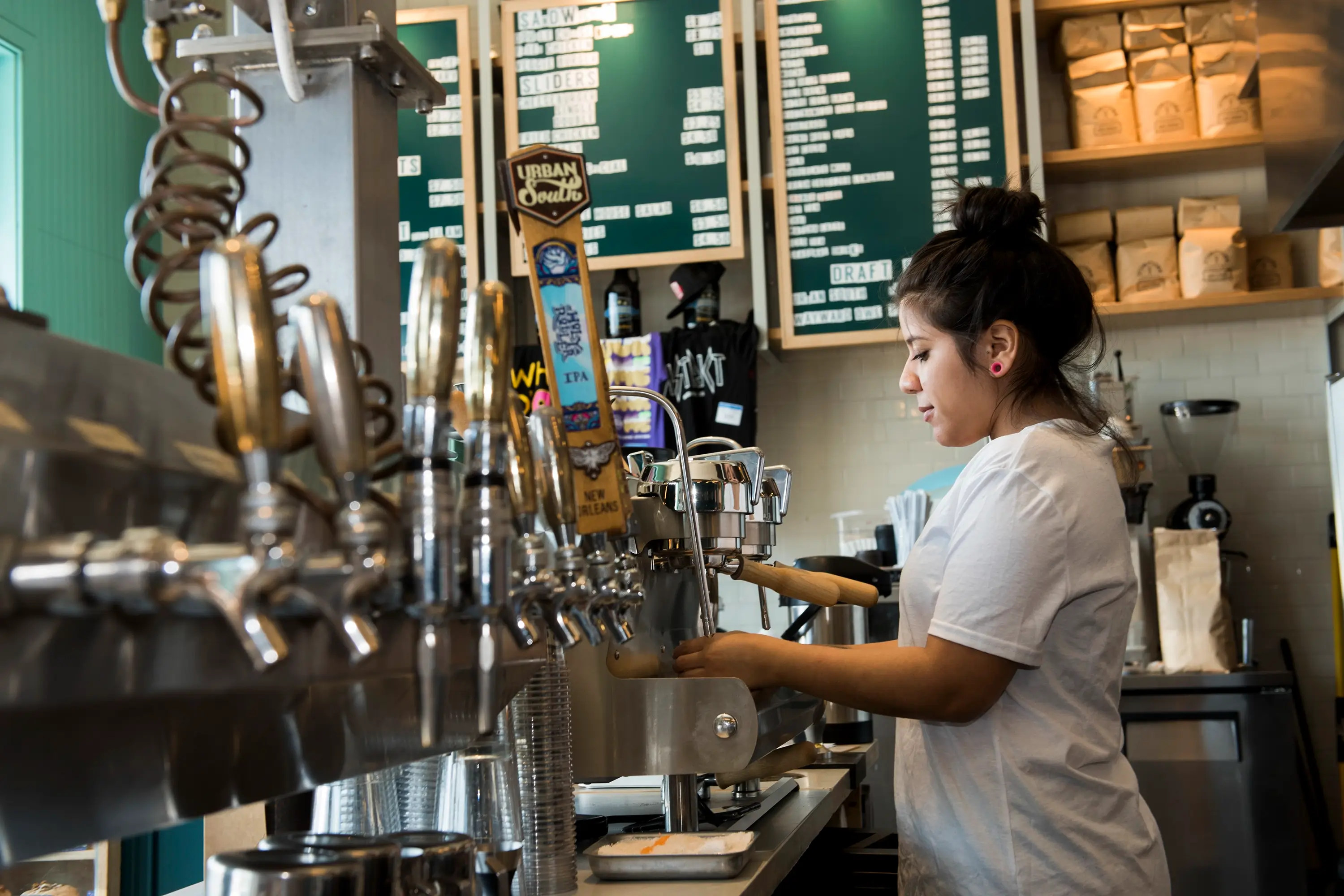 A barista working at District Donuts Coffee