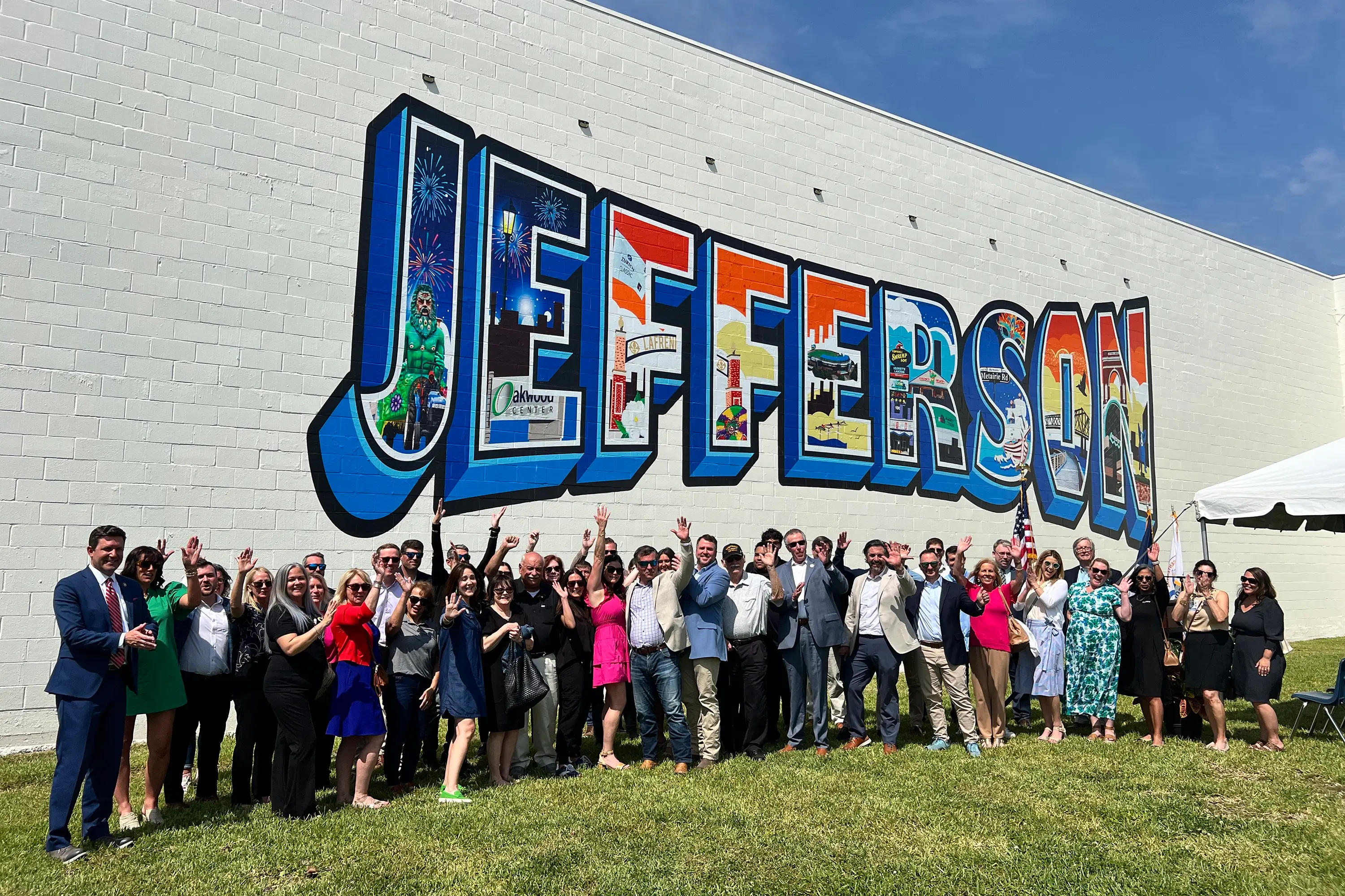 A crowd in front of the Jefferson lettering mural on a blank wall