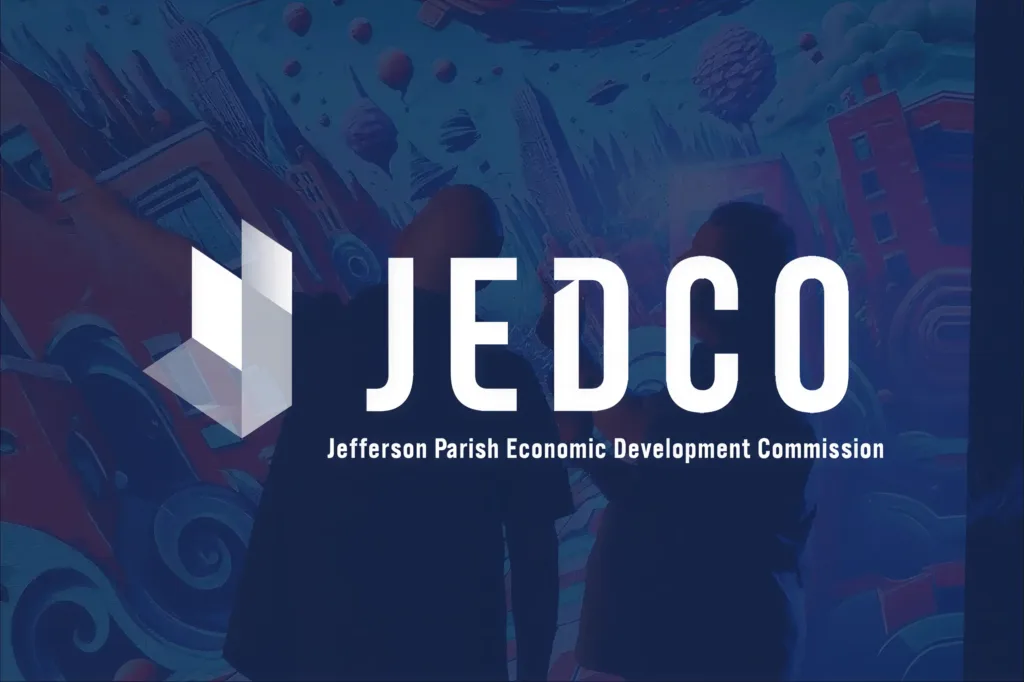 Two people looking and pointing at an illustration on a large screen, overlaid with a JEDCO logo