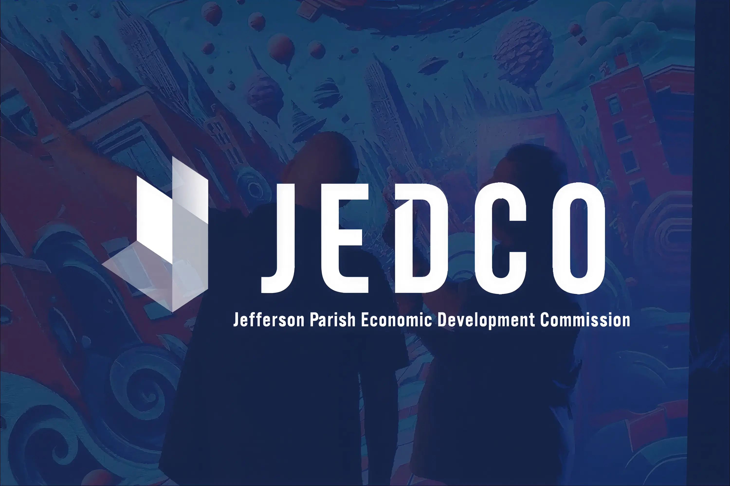 Two people looking and pointing at an illustration on a large screen, overlaid with a JEDCO logo