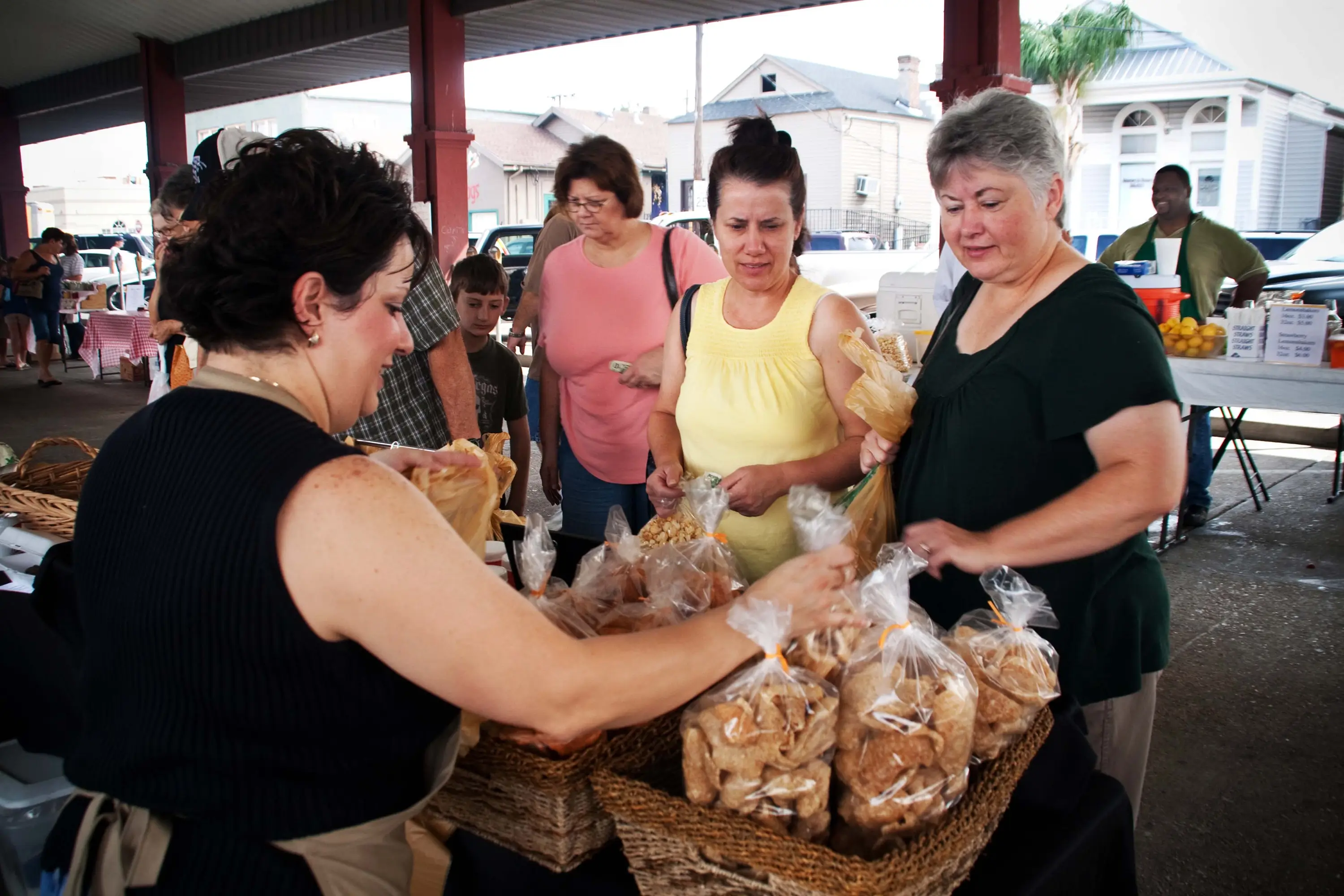 A woman selling goods in bags at the Gretna Farmers Market