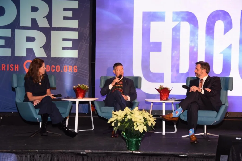 A group of people sitting on a stage at a luncheon conference