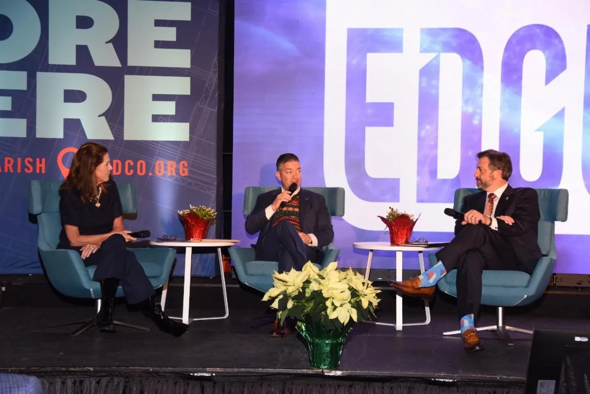 A group of people sitting on a stage at a luncheon conference